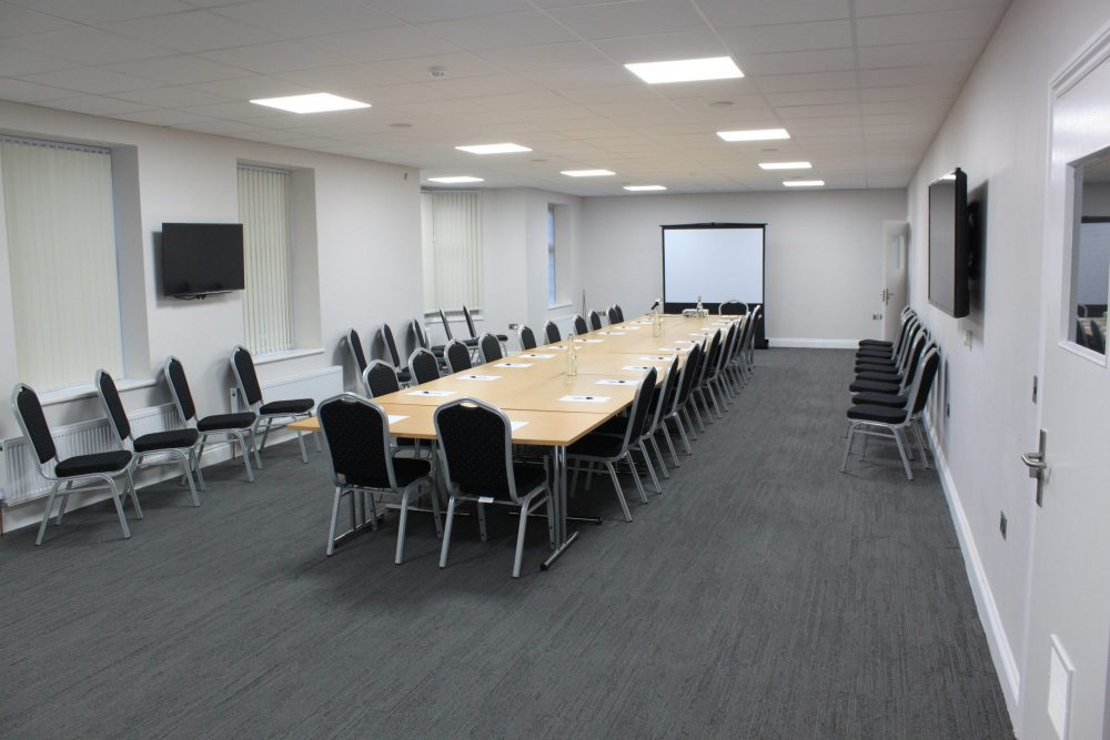 Function room in AMI Spaces with long table setup for workshops and meetings.