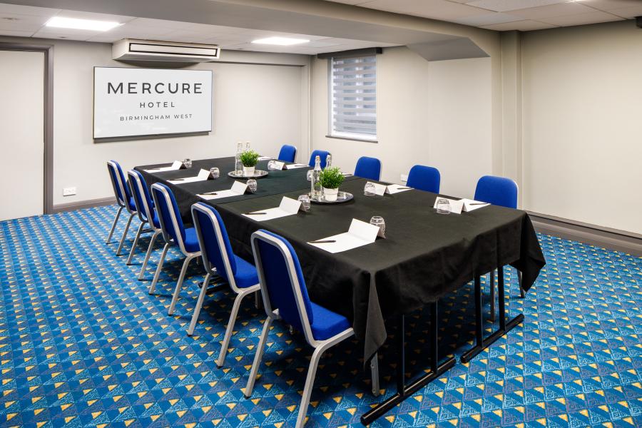 Duffield Room at Signing Tree Venue, elegant meeting space with natural light and blue chairs.