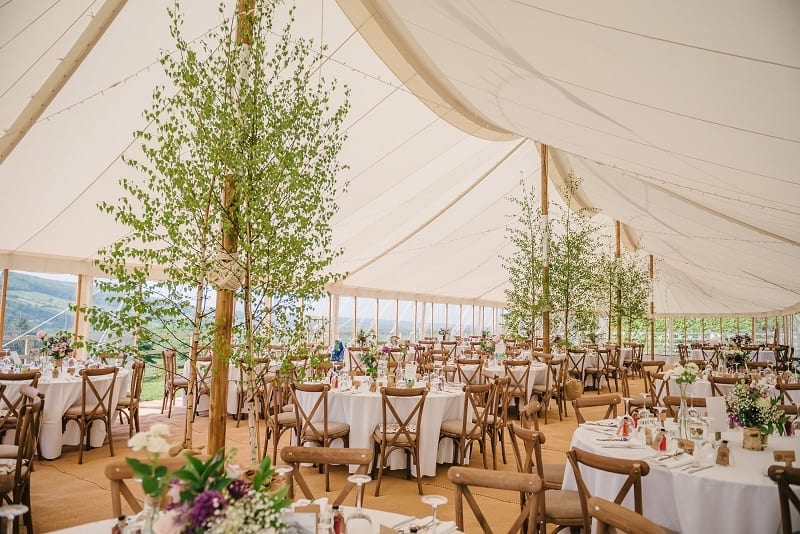 Elegant tented event space with floral centerpieces for weddings and upscale gatherings.