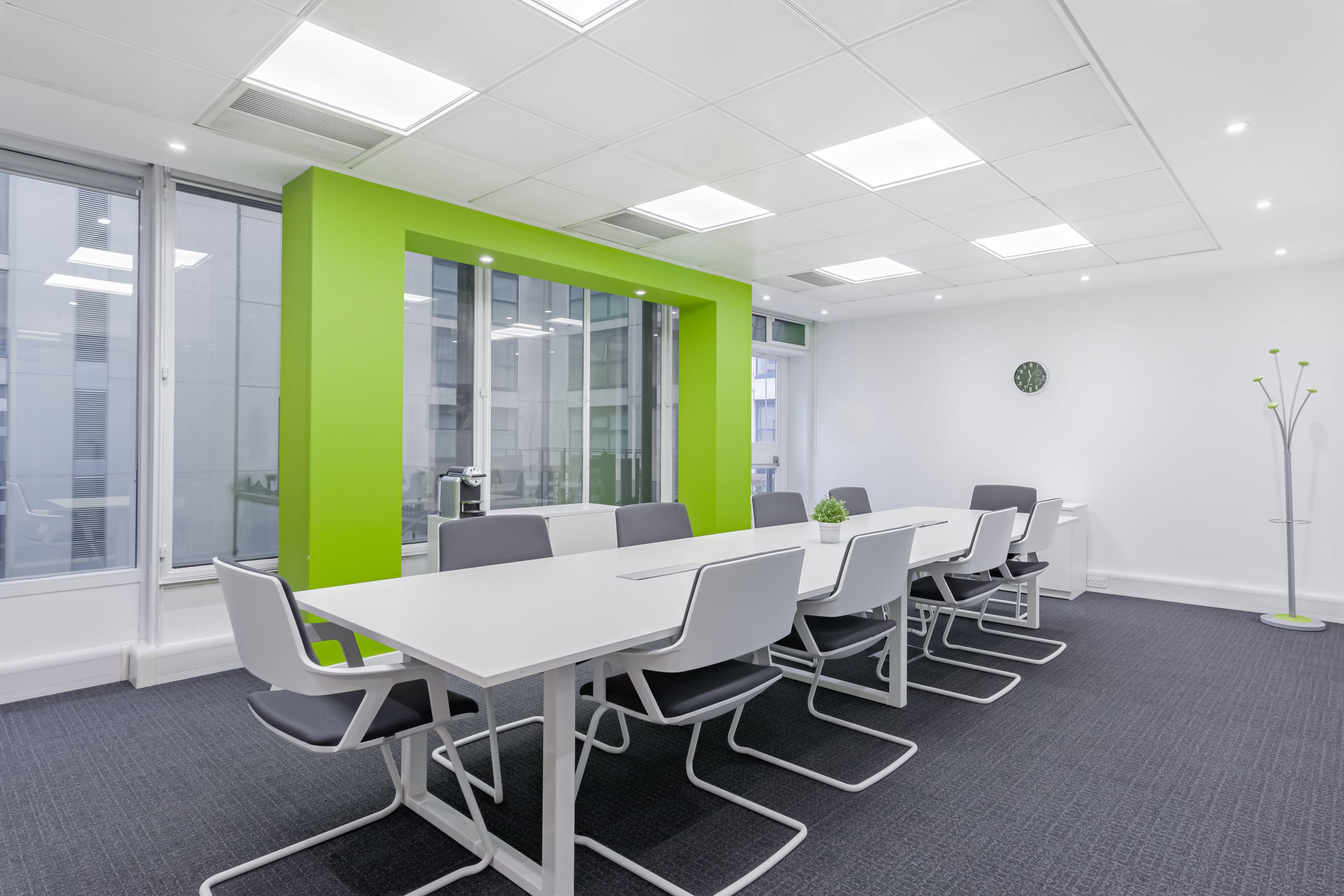 Modern meeting room at 1 Victoria Square, Birmingham with white table and green accent wall.