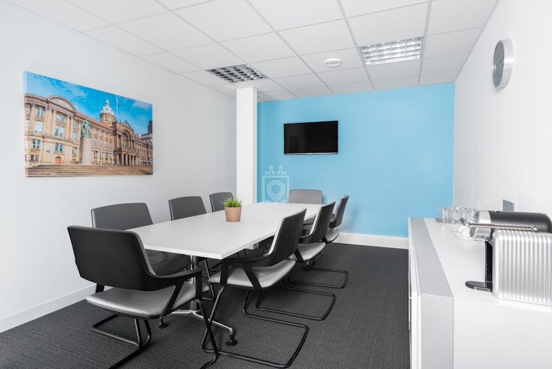 Modern meeting room in Birmingham with sleek table, ideal for collaboration and presentations.