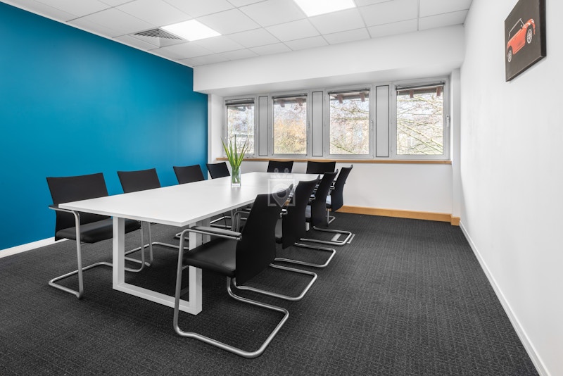 Modern meeting room with white table and black chairs in Birmingham City Centre.