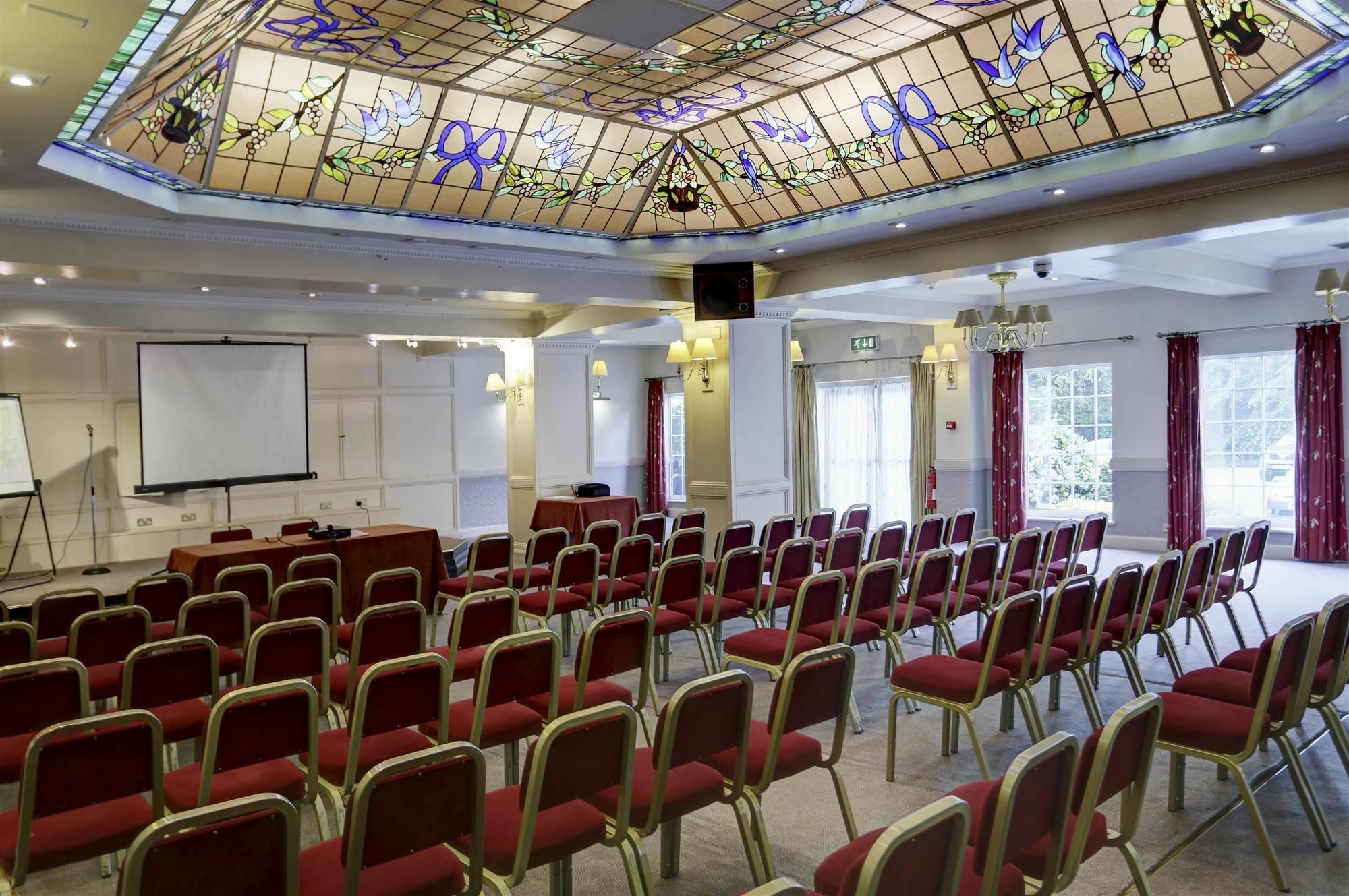"Elegant meeting room with stained glass ceiling for workshops and conferences at Westley Hotel."