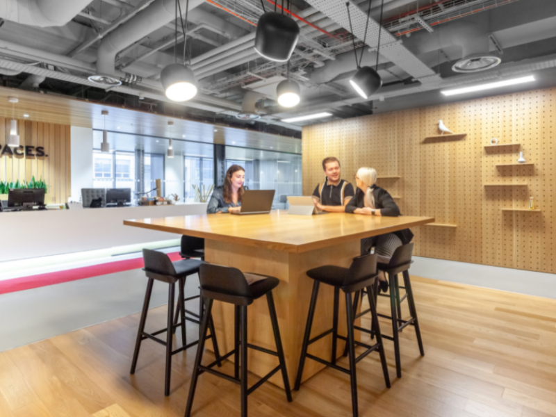 Modern collaborative workspace with large wooden table for meetings and events.