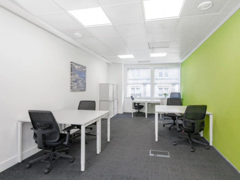 Modern virtual office meeting space with green accent wall for collaborative sessions.