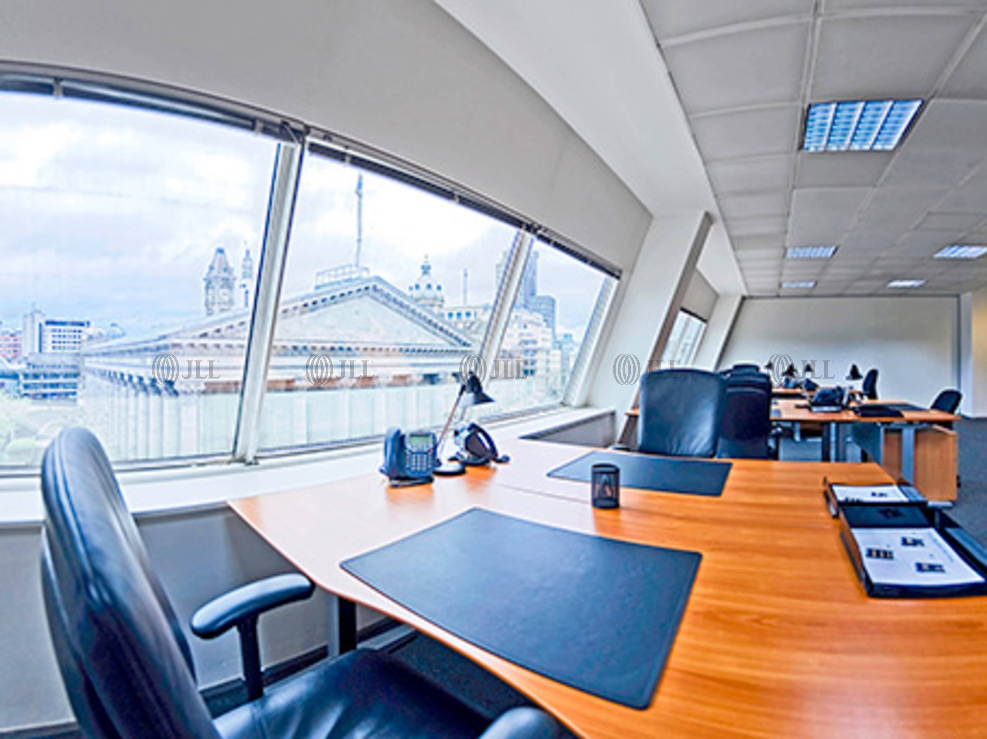 Modern meeting room with large windows, ideal for workshops and collaborative events.