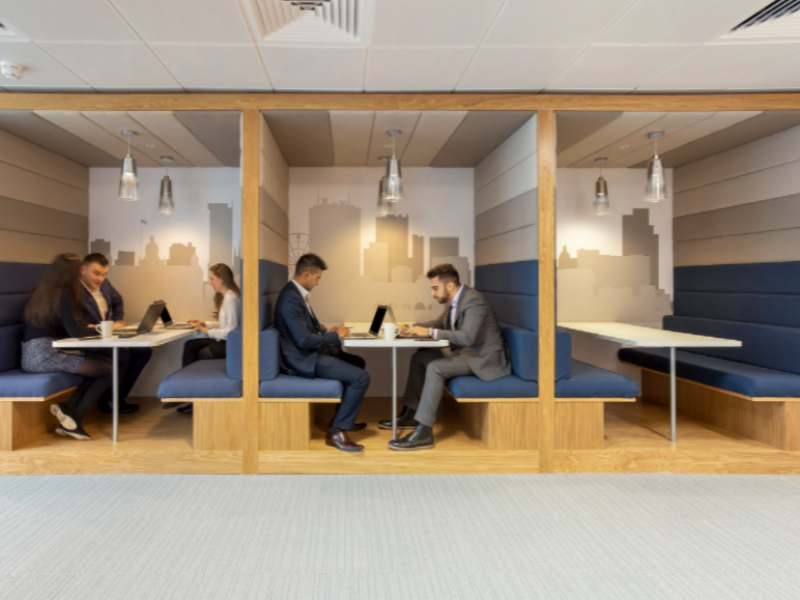 Modern virtual office meeting space with cozy booths for collaboration and brainstorming.