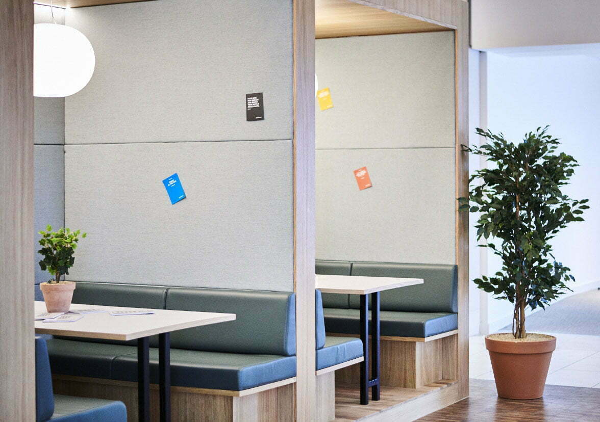 Modern meeting space with cozy booths and greenery for creative events at Spaces The Mailbox.