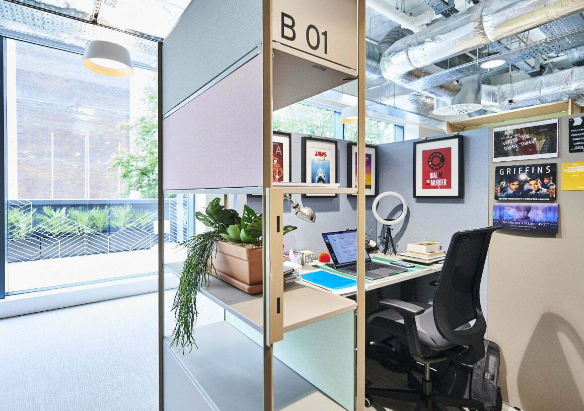 Modern workspace at Spaces The Mailbox, featuring a collaborative desk and greenery.