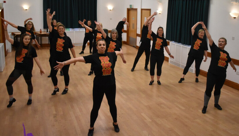 Dynamic dance rehearsal at Chloe May's Dance Academy, showcasing teamwork and energy.