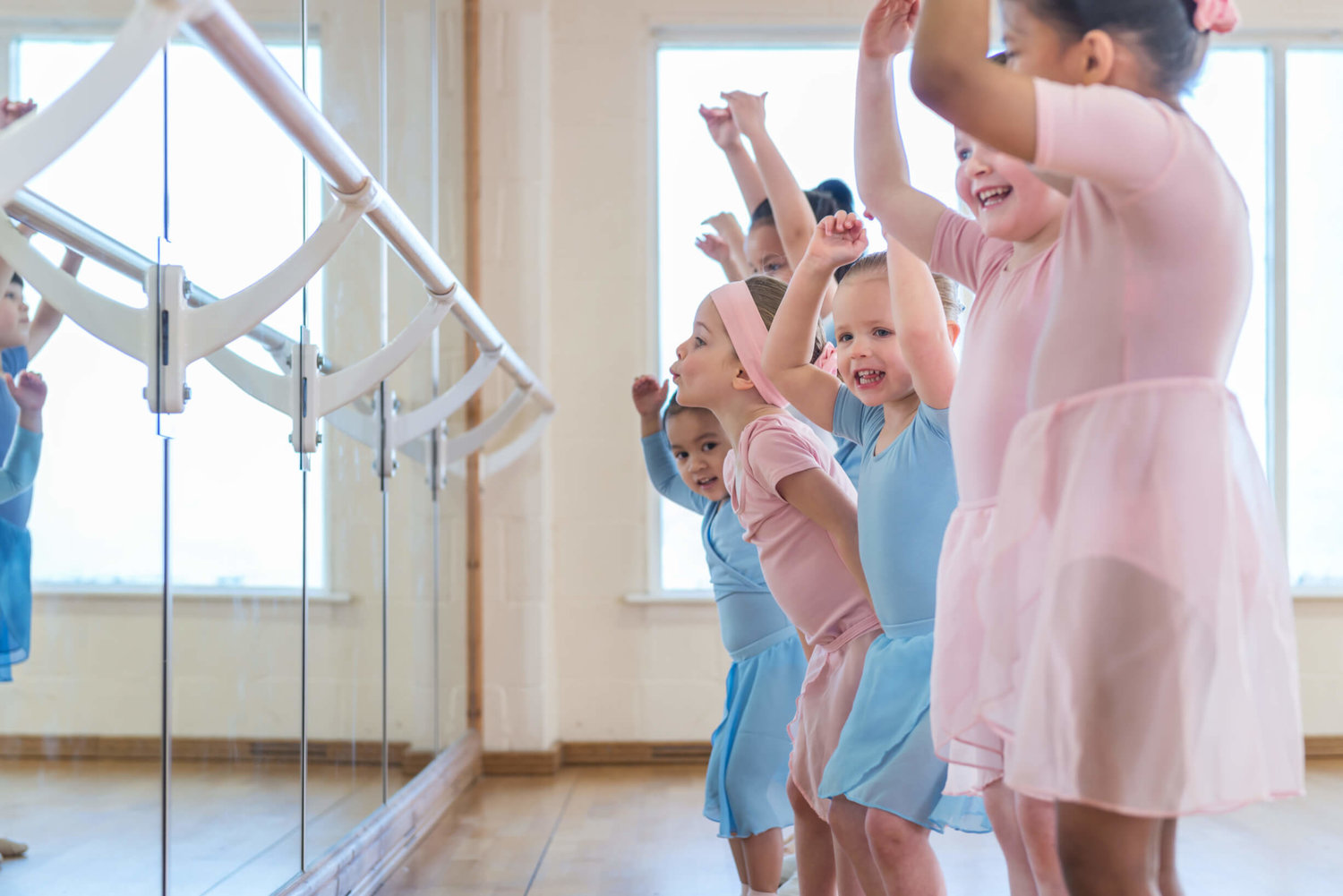 Children dancing in bright Rutleigh Norris School of Dance foyer for family workshops.
