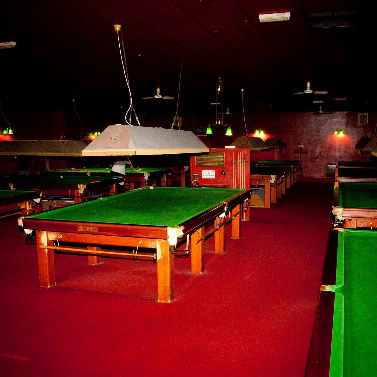 Spacious snooker room with vibrant green tables for team-building and networking events.