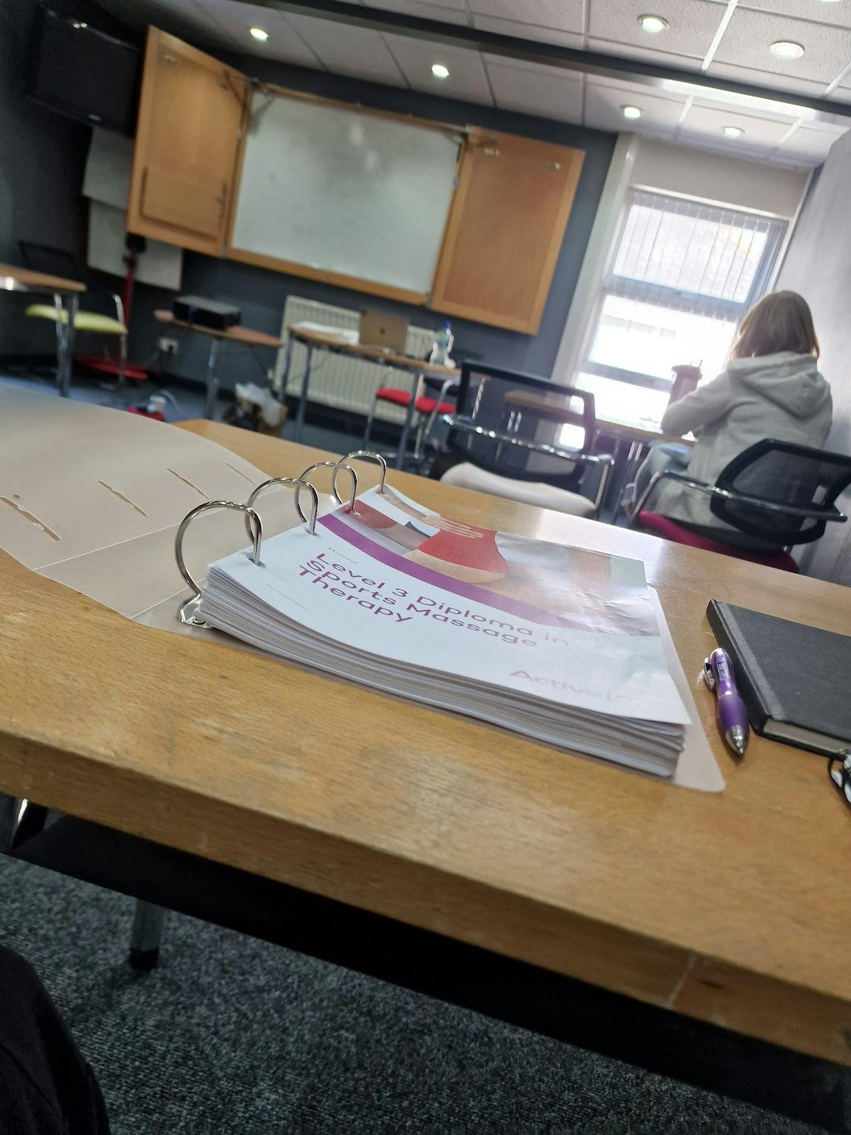 Conference room with organized binder for training session at Hollyfields Centre.