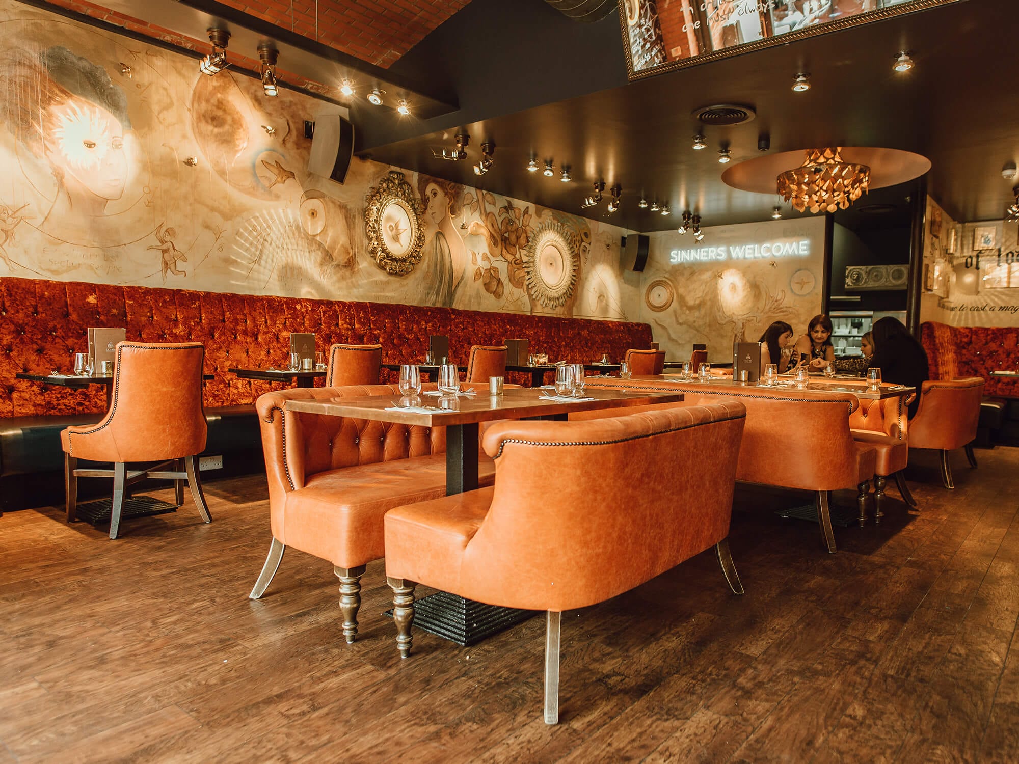 Stylish Aluna Birmingham restaurant with plush orange seating for events and gatherings.