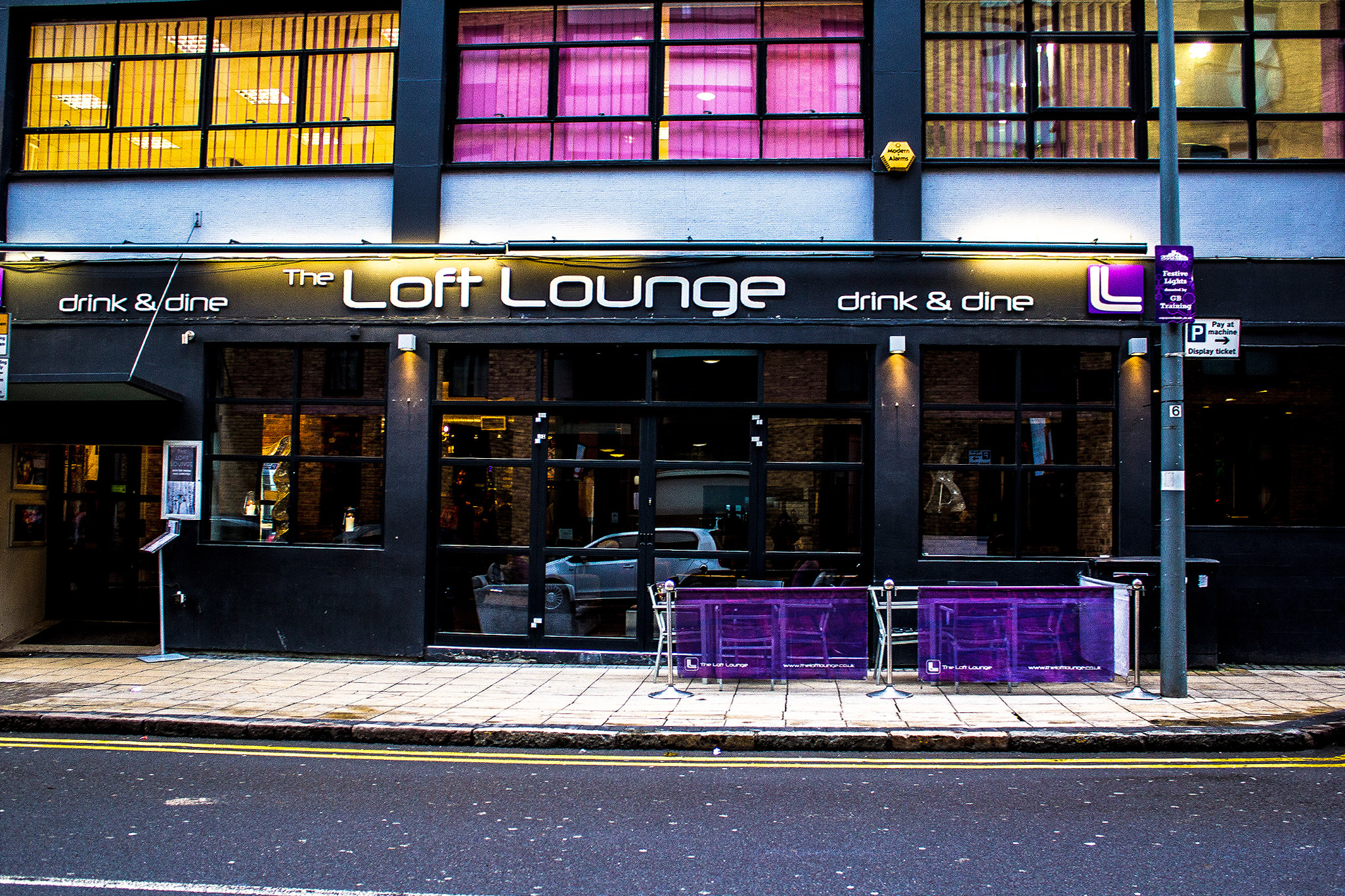Modern event venue The Loft Brum with large windows and outdoor seating for gatherings.