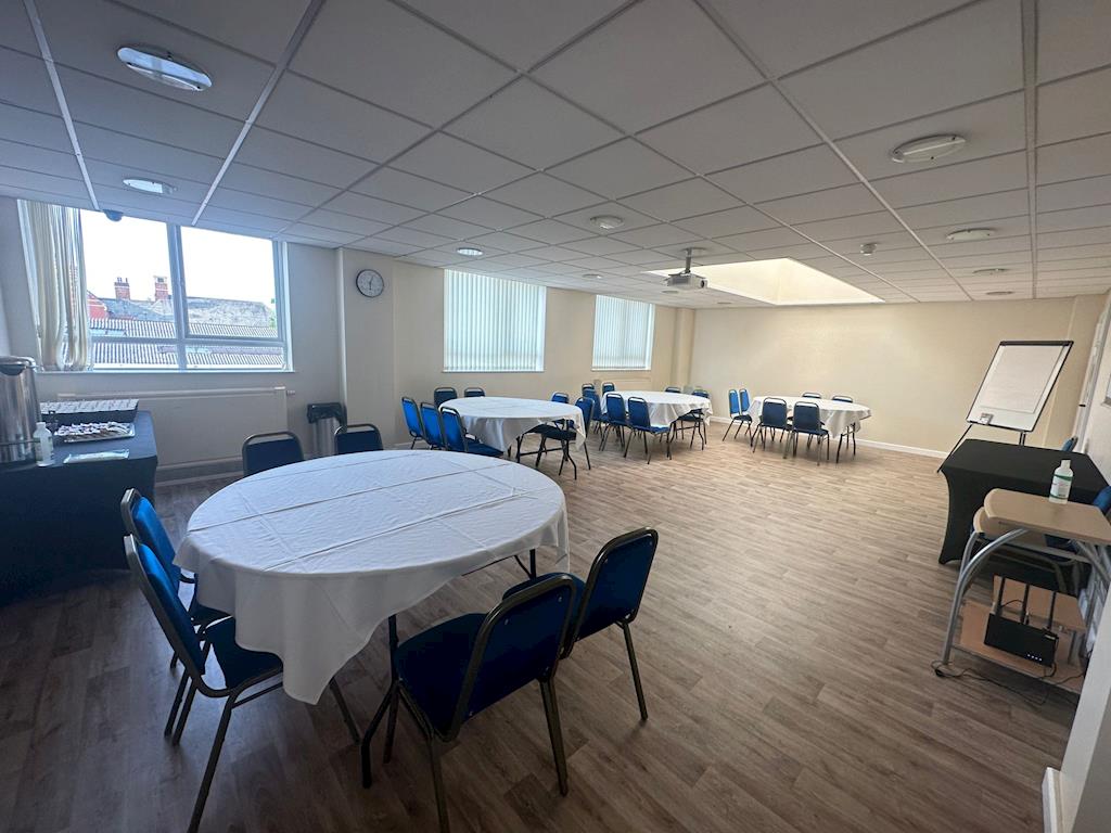 Conference center with round tables, ideal for workshops and team meetings.