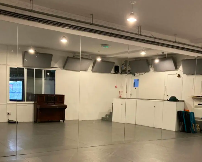 Versatile event space with mirrored walls, ideal for workshops and meetings.