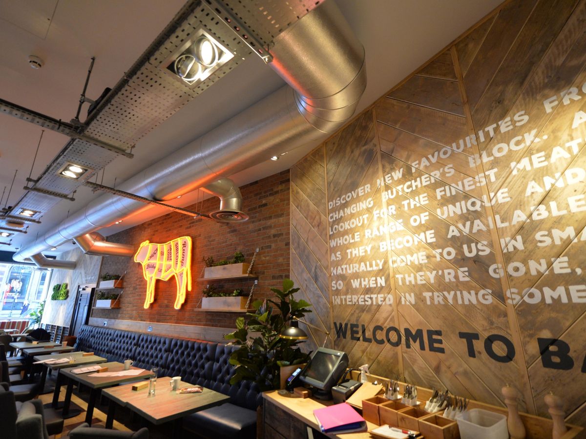 Modern bar in Beefeater Birmingham with neon cow sign, perfect for culinary events and networking.