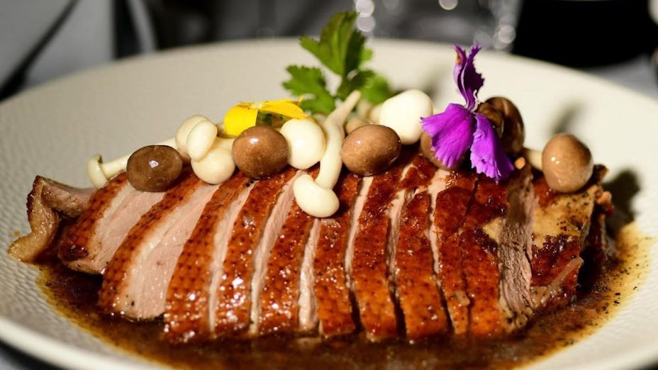 Private dining suite with plated duck dish, perfect for events and meetings.