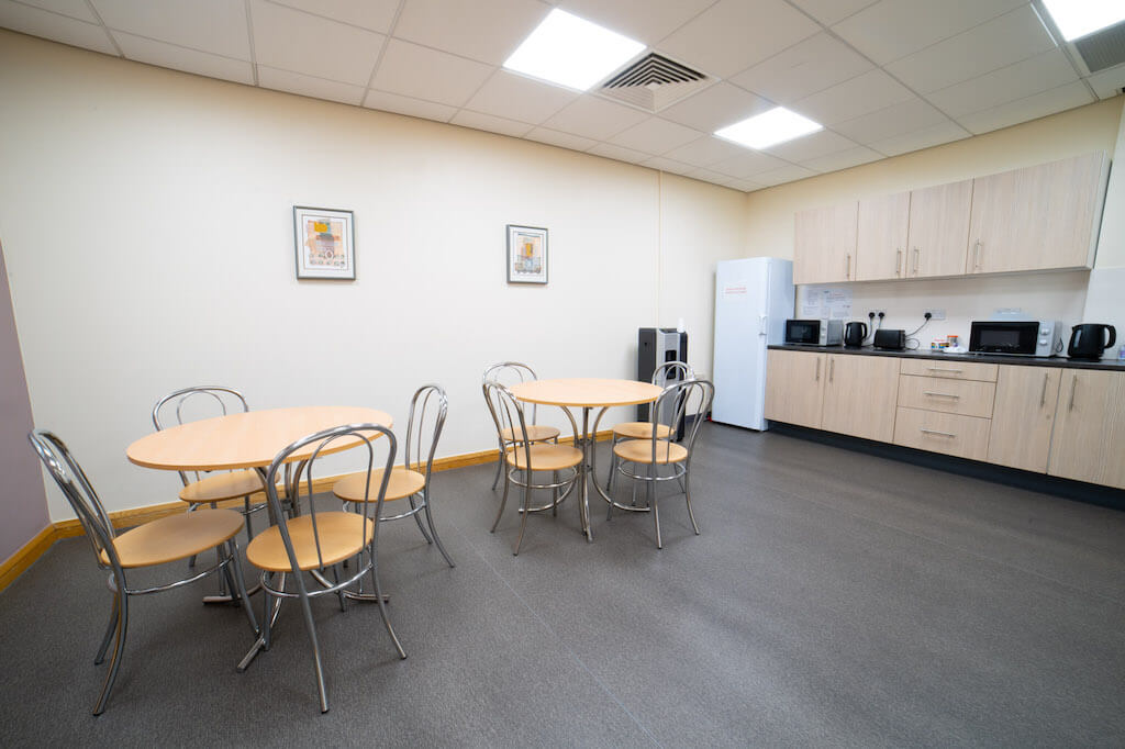 Blythe Room at Hollyfields Centre: round tables for meetings and events, calm decor.