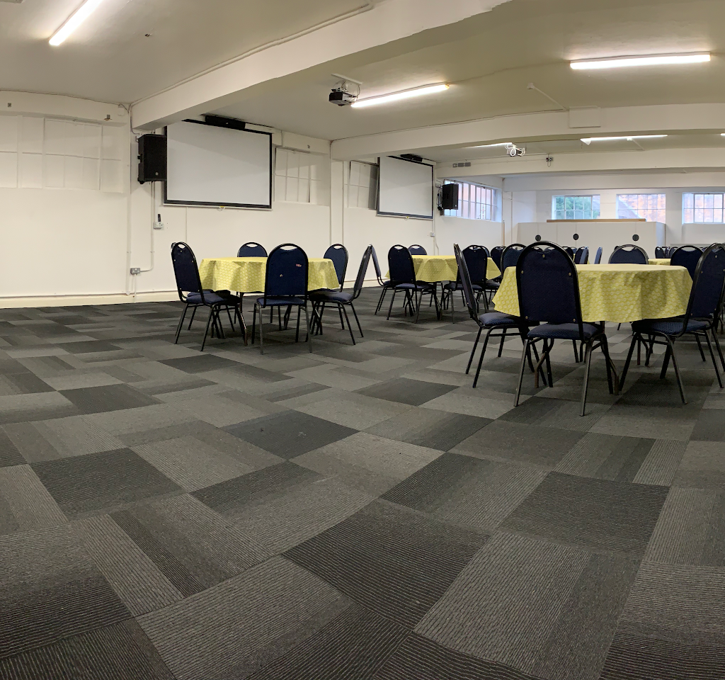 Versatile event space with yellow tablecloths for meetings and gatherings at OIKOS Café.