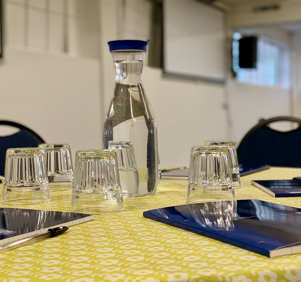 OIKOS Café meeting setup with water carafe, notepads for productive events.