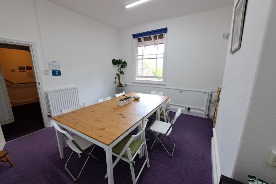 Bright Sycamore Room with wooden table, ideal for meetings and workshops.