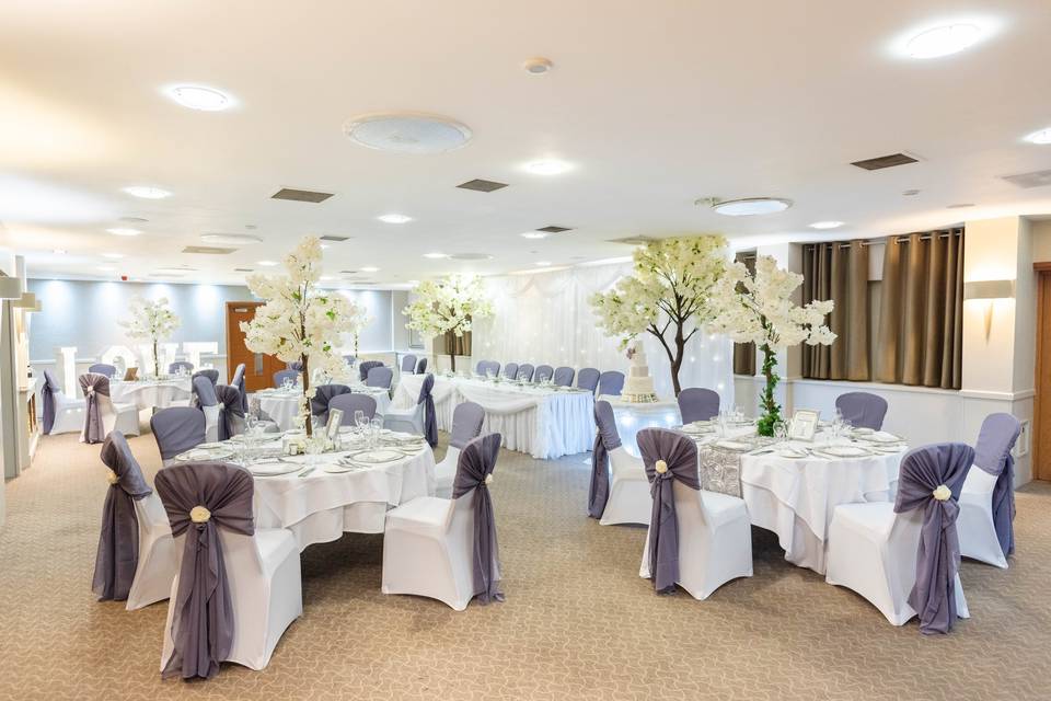 Elegant wedding venue at Lea Marston Hotel with floral centerpieces and soft lighting.