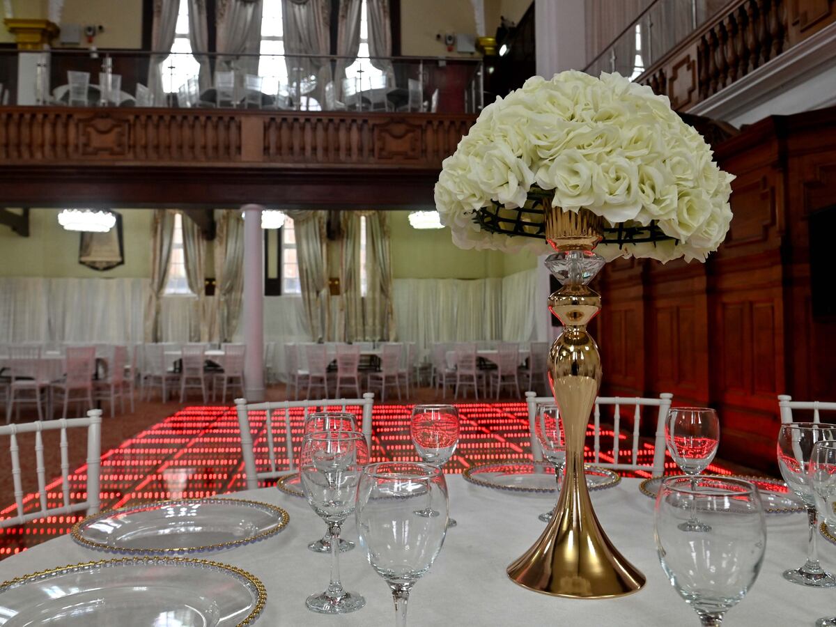 Elegant dining table with white roses at The Grand Palace for upscale events.