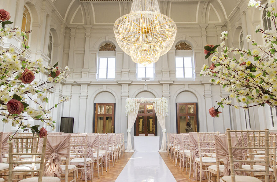 Elegant wedding venue at The Grand Palace with blush seating and stunning chandelier.