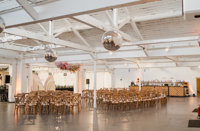Factory Works venue with round tables, ideal for corporate events and celebrations.