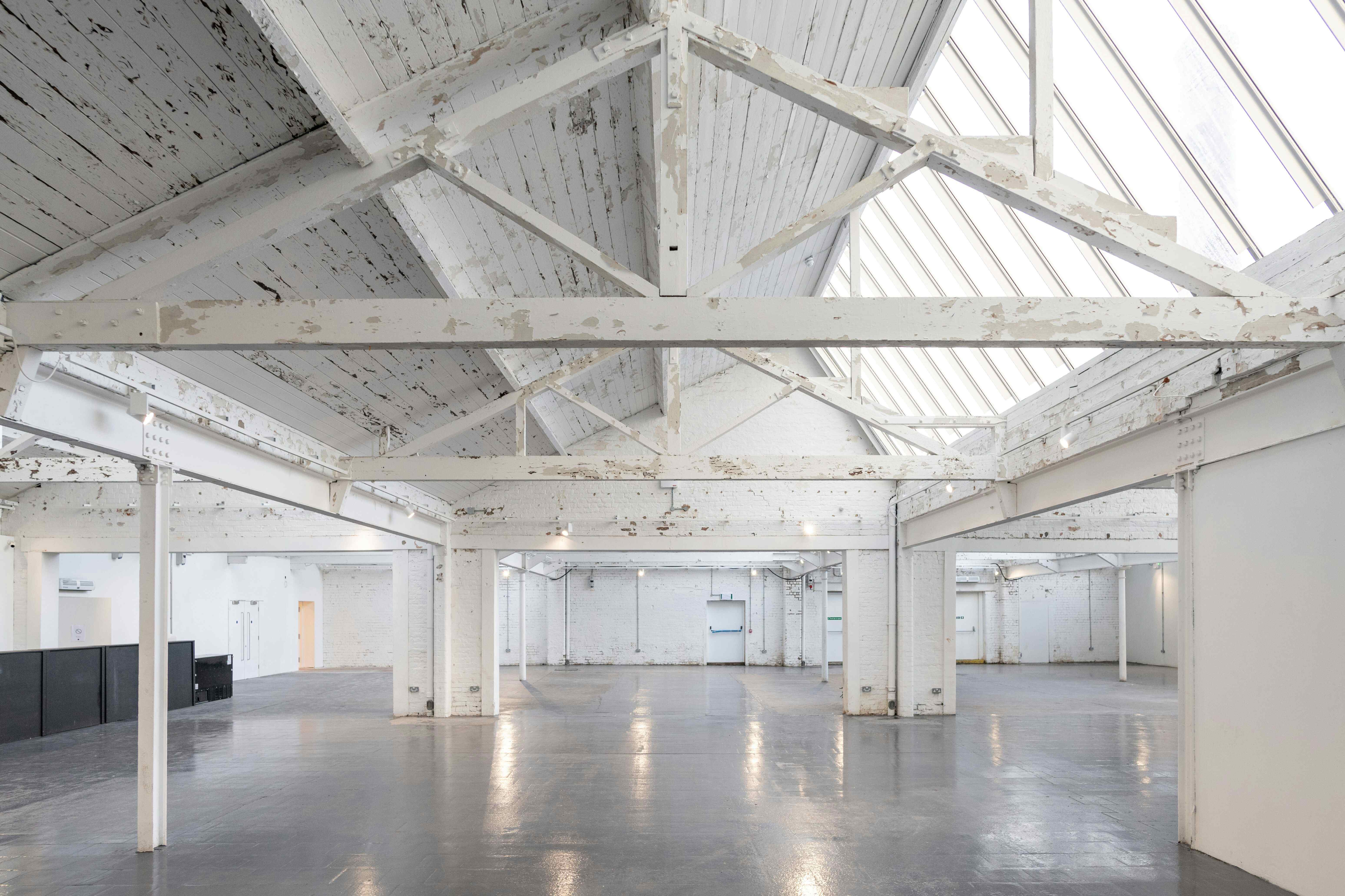 Spacious industrial event venue with high ceilings for creative gatherings and conferences.