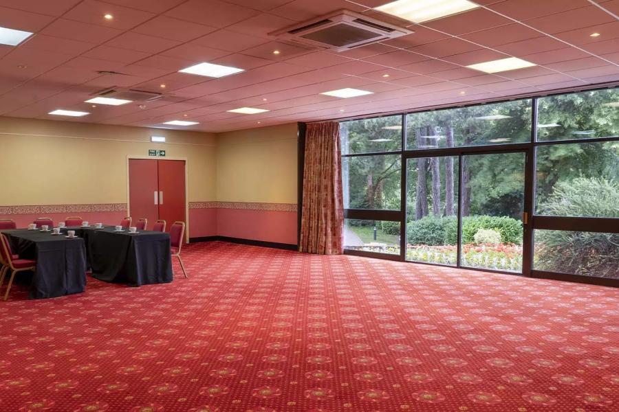 Versatile meeting space with natural light, ideal for events and gatherings.