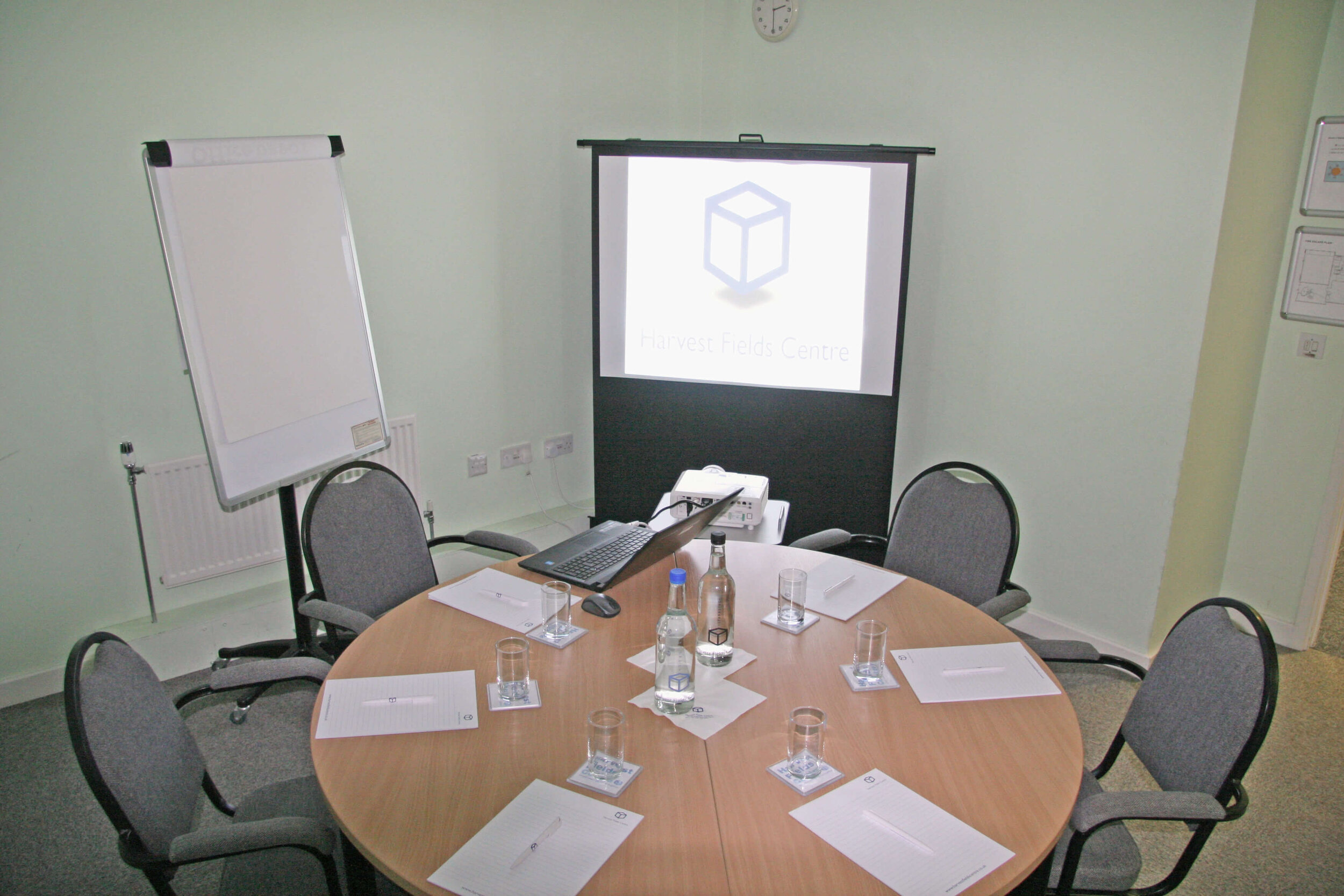 Meeting room with round table, projector screen for collaborative discussions and presentations.