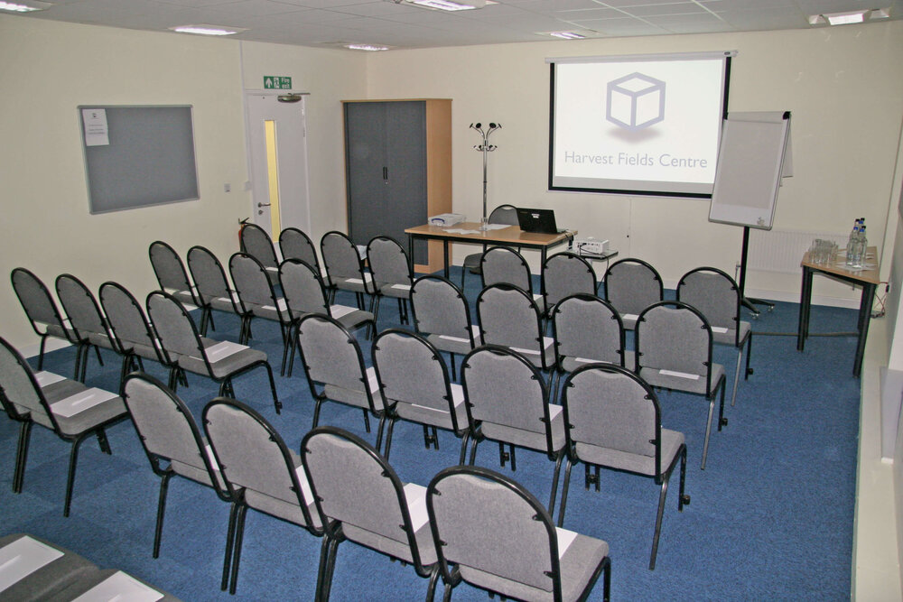 Meeting room setup with projector screen for presentations at Harvest Fields Centre.