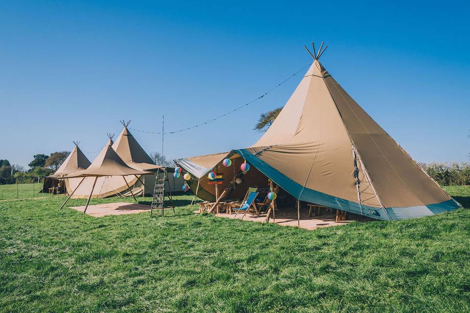 Outdoor event space with stylish tipis, ideal for weddings and festivals.