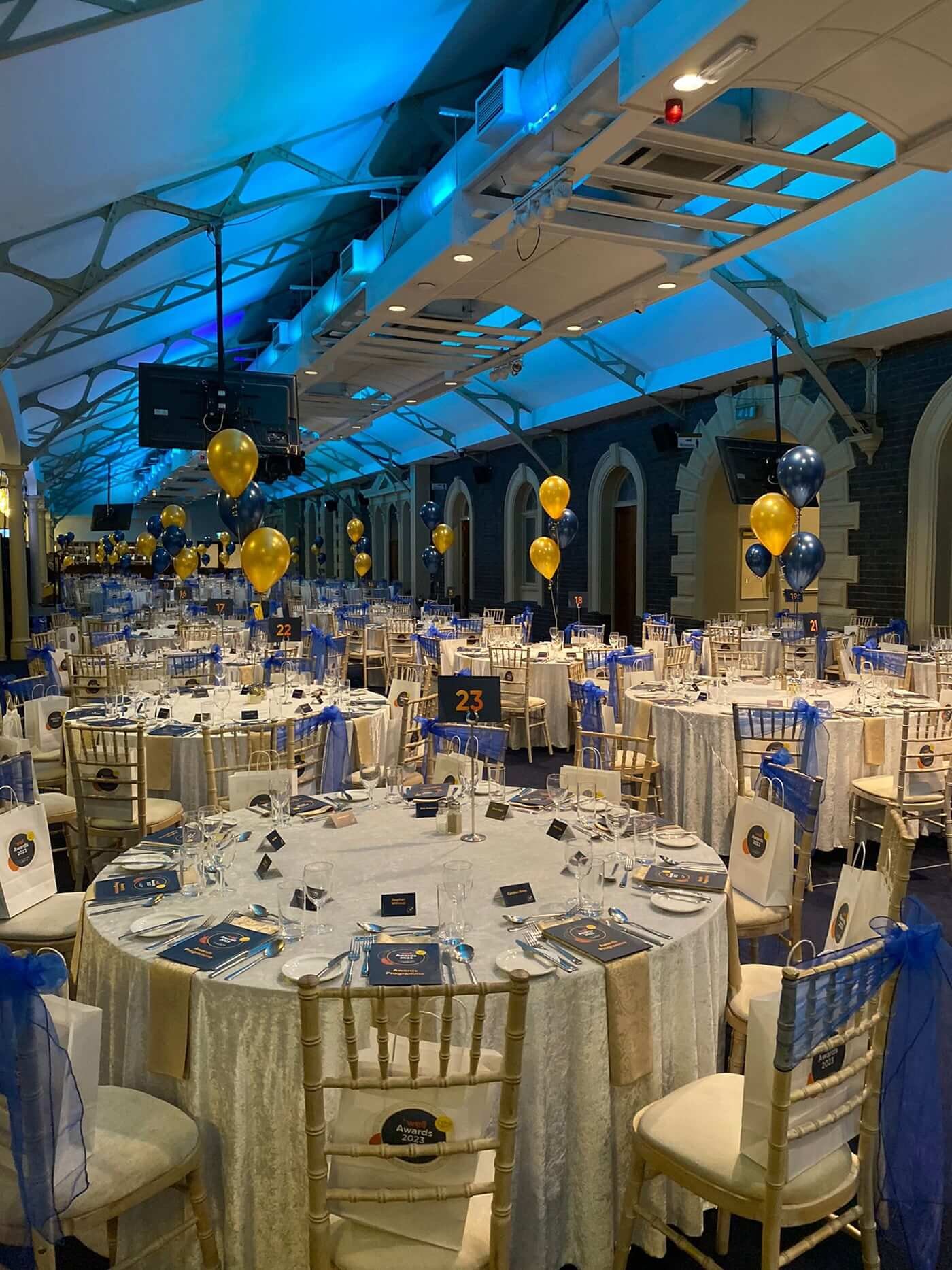 Elegant event space at Grand Station with round tables, balloons, and ambient lighting.