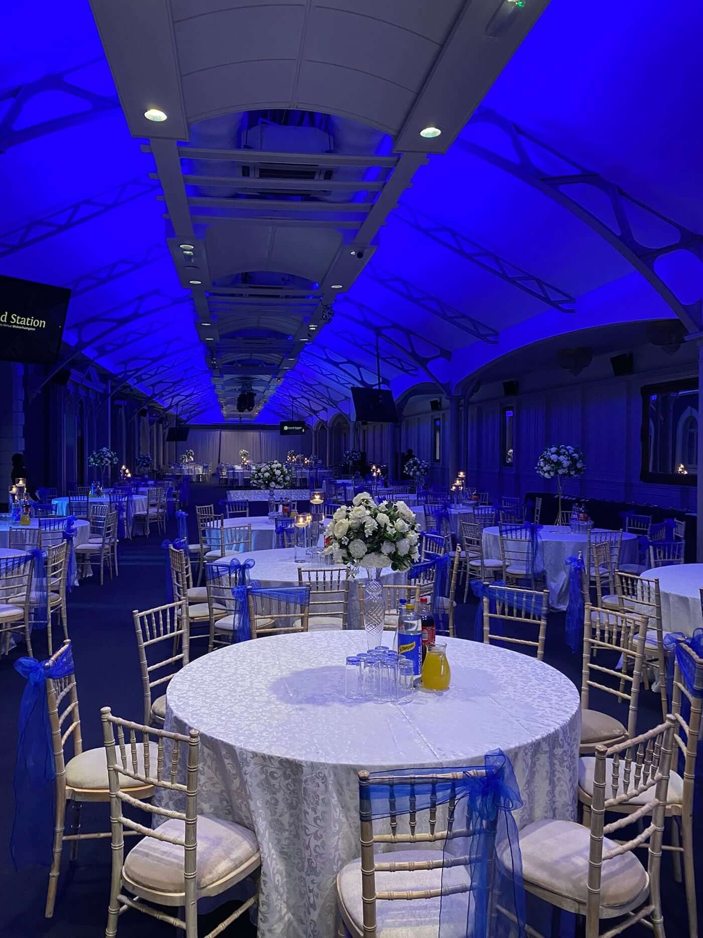 Elegant event space with round tables, blue accents for corporate parties and celebrations.