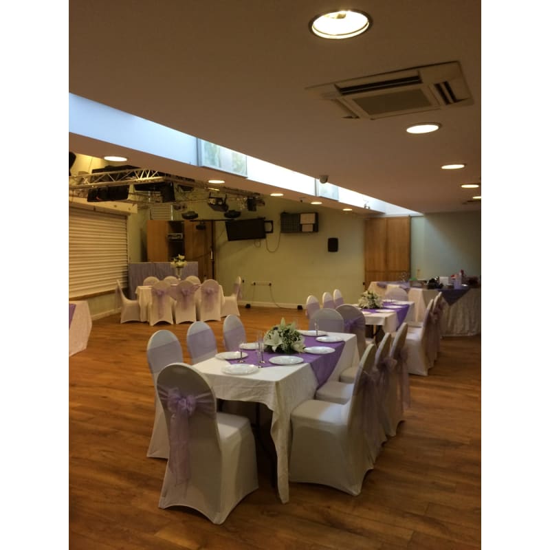 Elegant event space with white linens and purple accents at The Oak Tree Centre.
