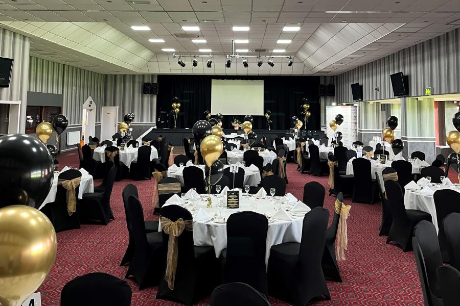 Elegant Albert McPherson Lounge set for formal corporate event with black and gold decor.