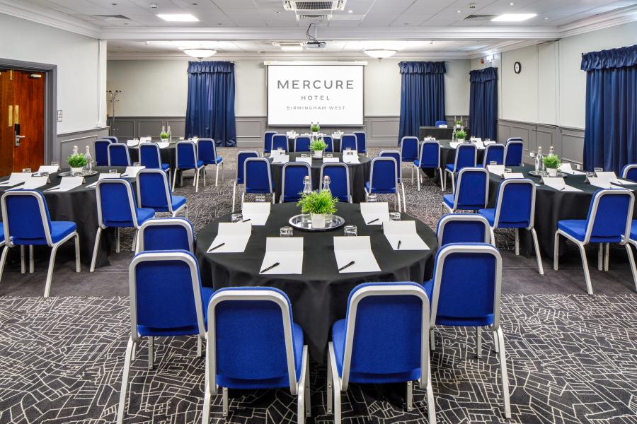 Conference room with round tables, ideal for corporate events and meetings.