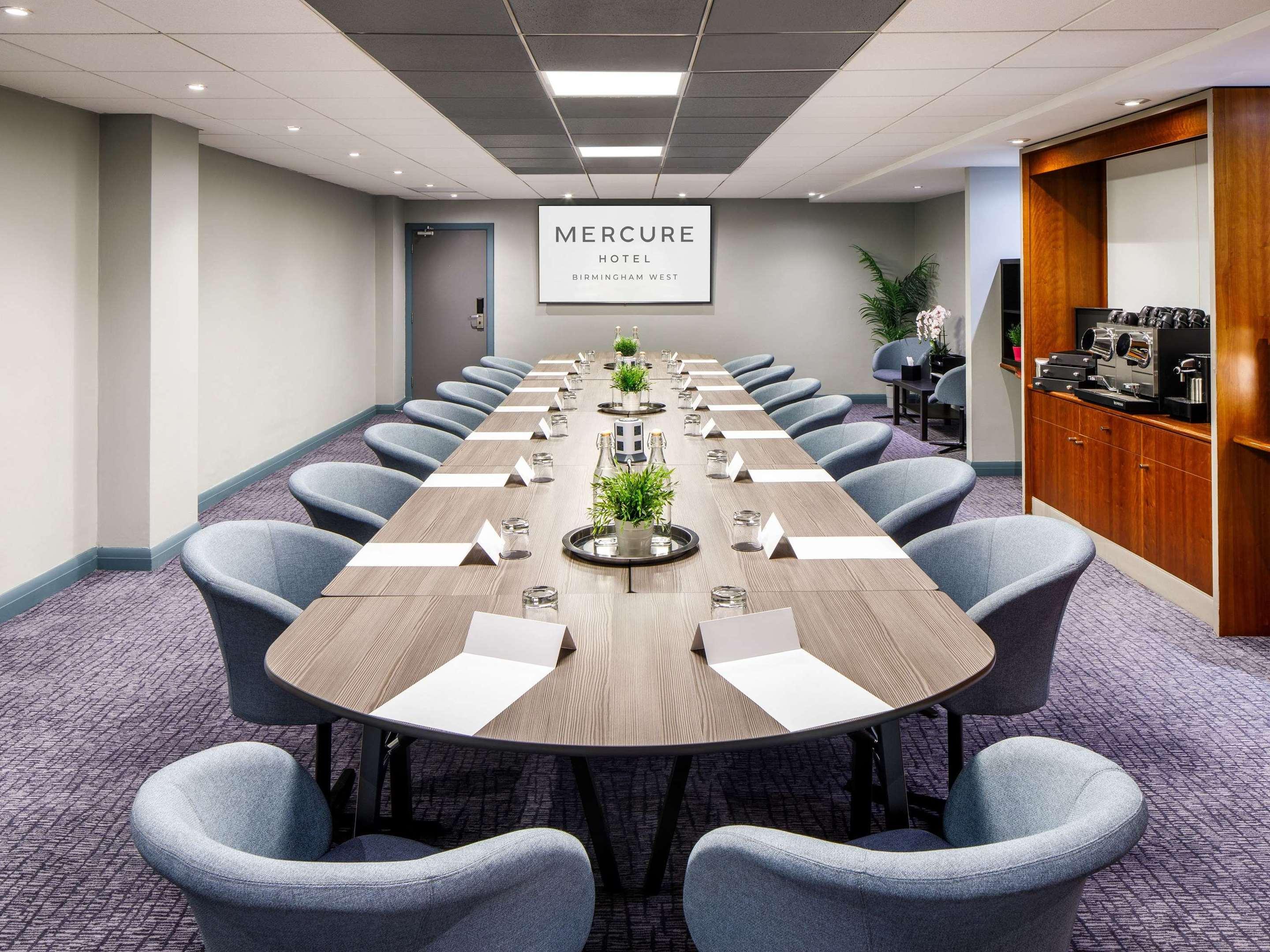 Conference room with oval table, notepads, ideal for meetings and events.