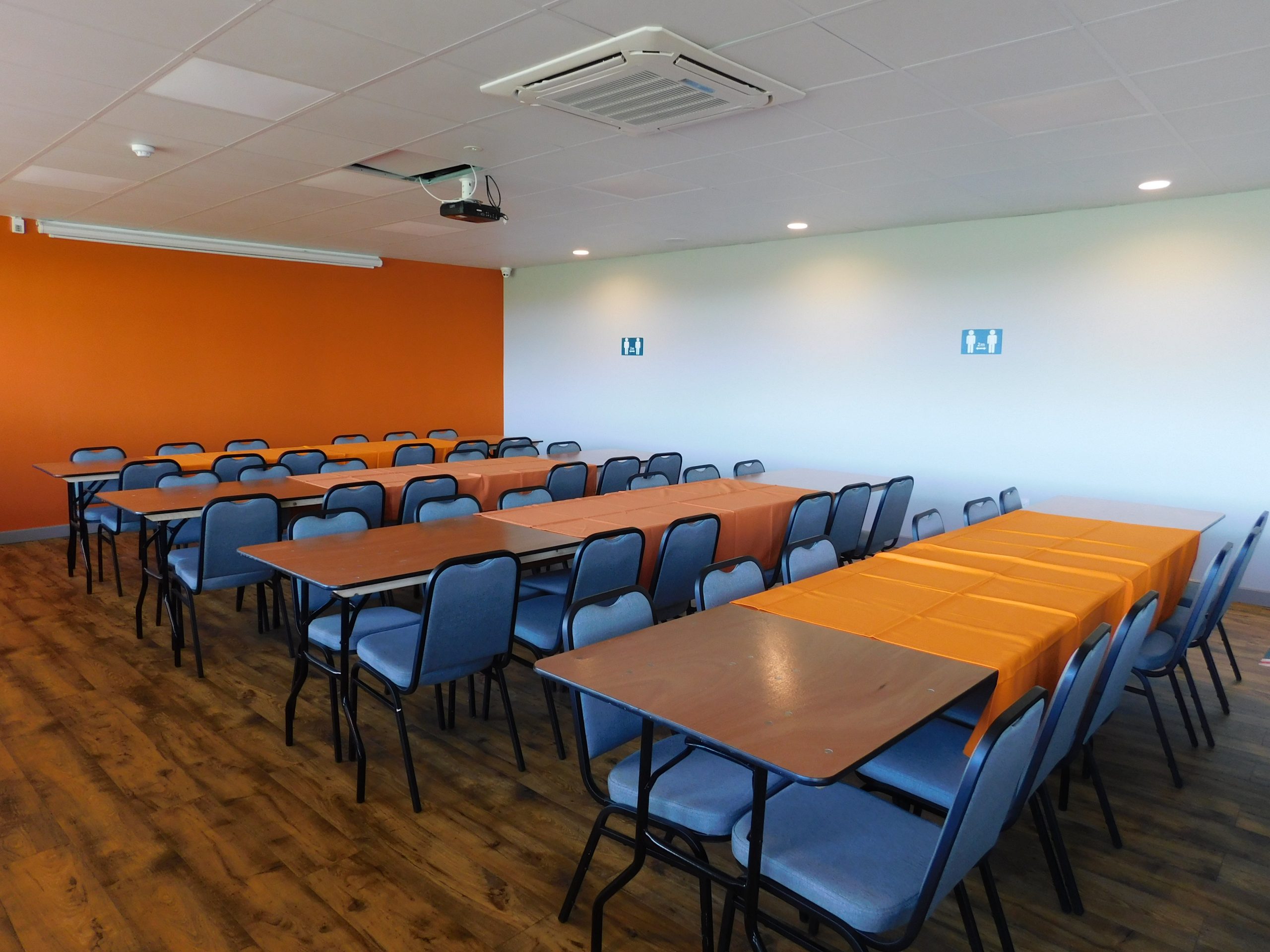 Sports bar meeting space with orange accent wall, ideal for workshops and training events.