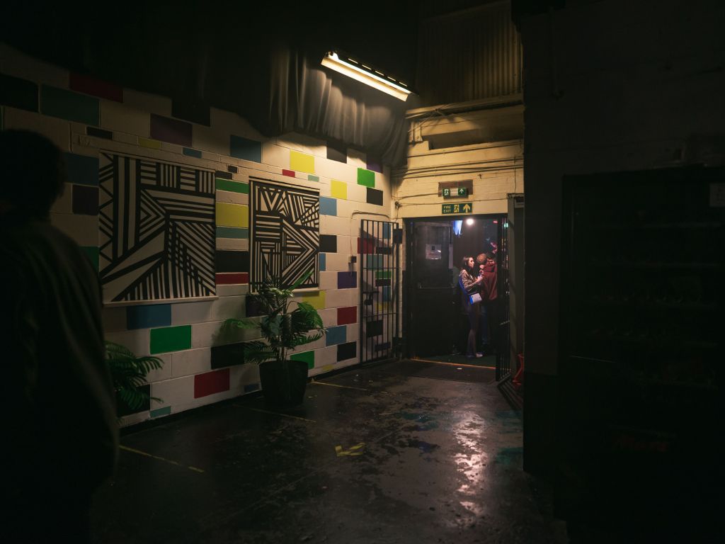 Vibrant corridor with colorful wall art in 7SVN warehouse for events and networking.