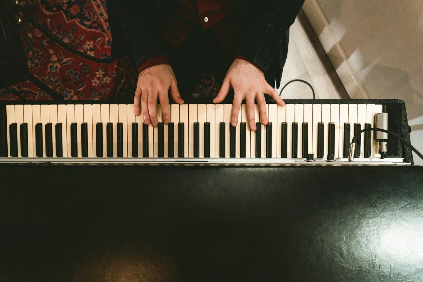 Pianist's hands over keyboard in elegant recording studio for live music events.