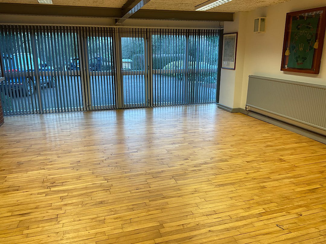 Spacious Dodford Village Hall with polished wood floors, ideal for workshops and networking.