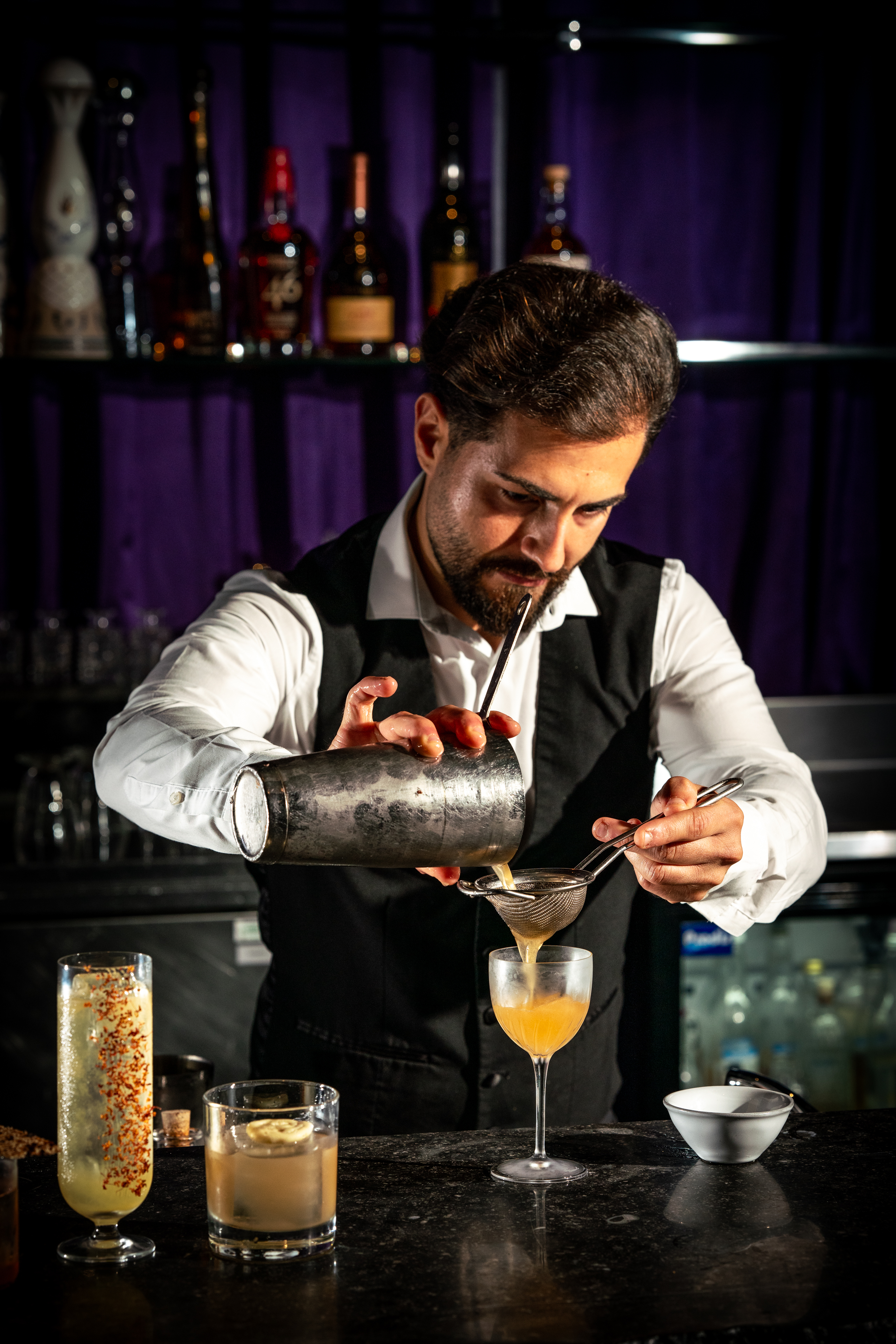 Bartender crafting a cocktail at Purple Bar, Sanderson London for event catering.