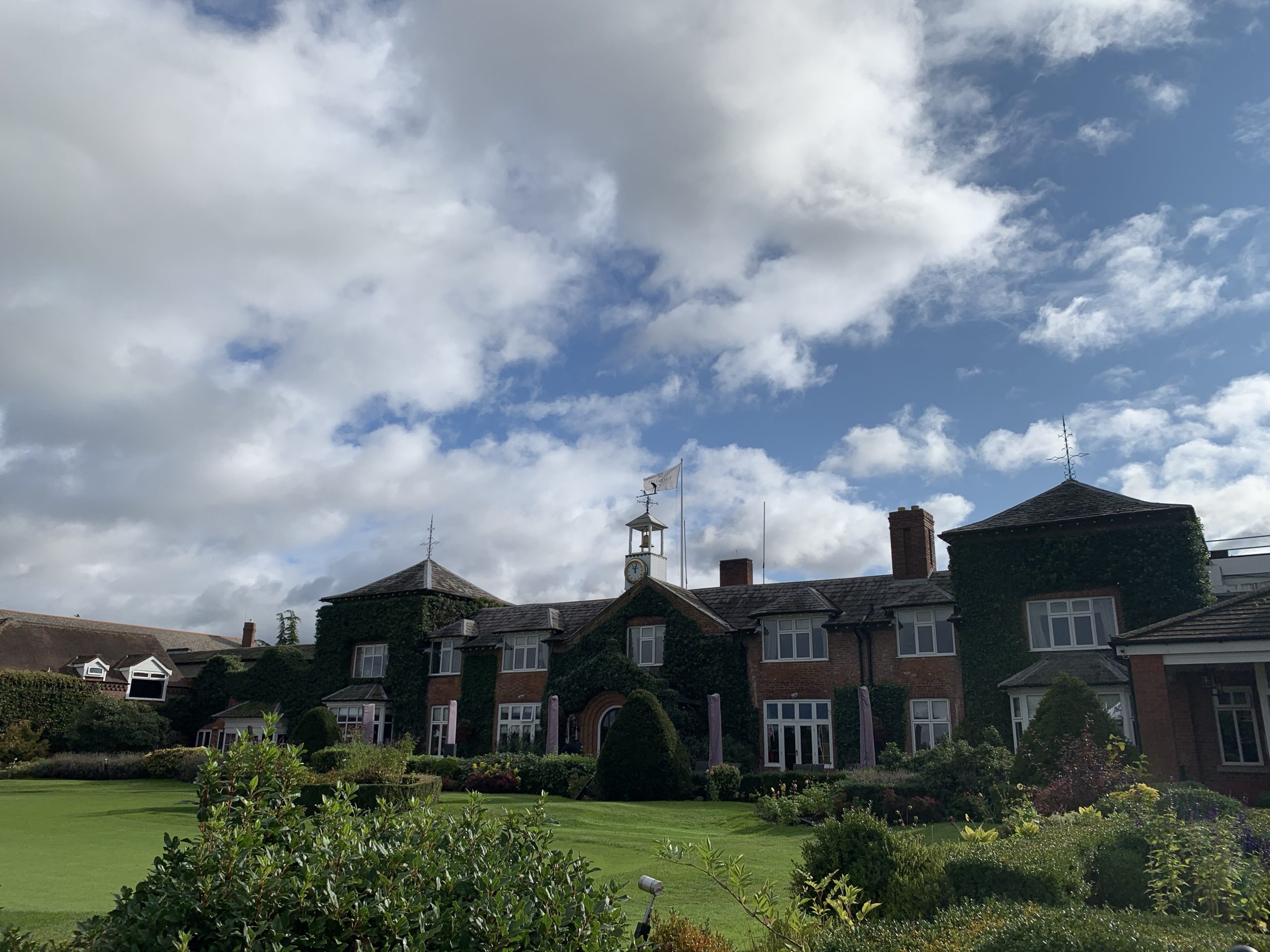 Charming brick venue for corporate retreats with scenic outdoor space and greenery.