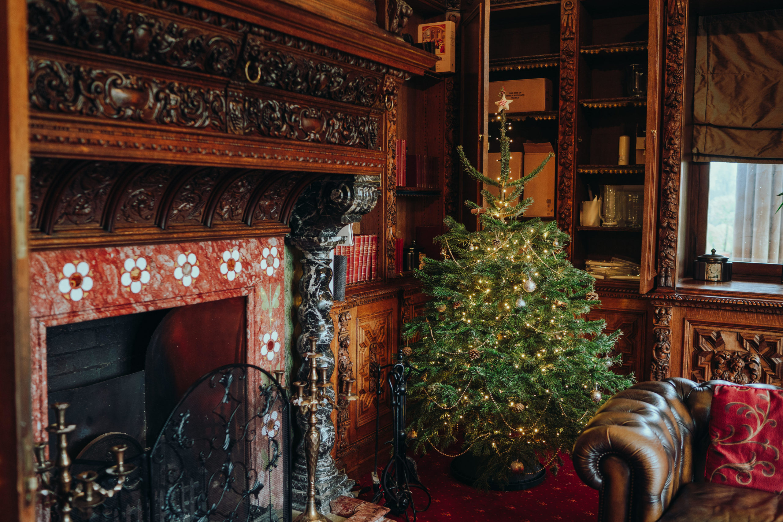 Christmas party at Manor by the Lake with a decorated tree and elegant fireplace.