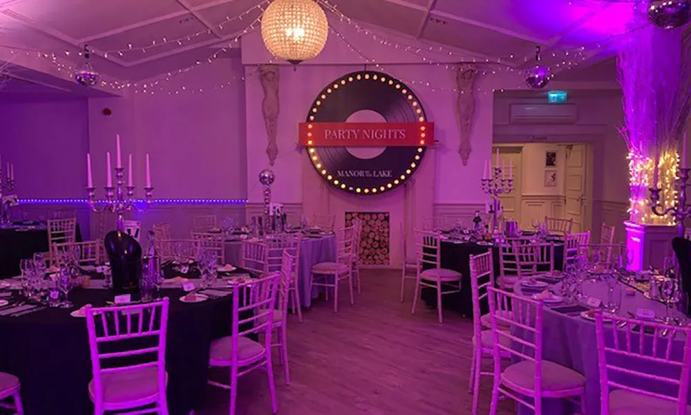 Christmas party setup with elegant tables and ambient lighting at Manor by the Lake.